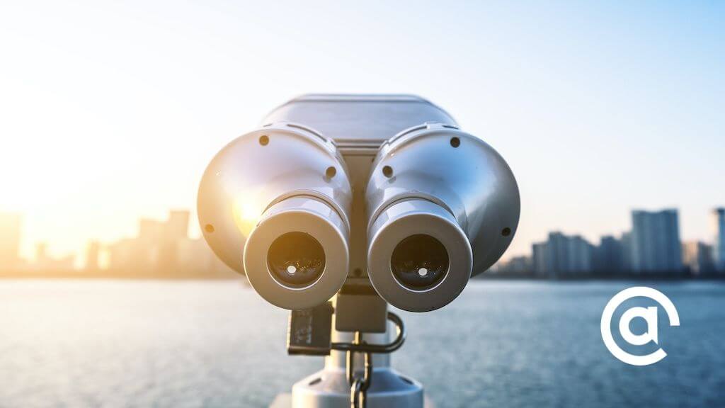 A tower viewer (binoculars that are permanently mounted on a stalk) point towards a city skyline, introduce our post.