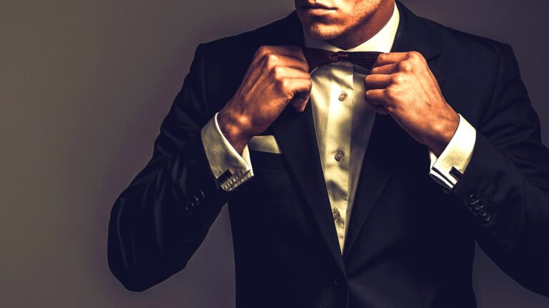 A man adjusts the bow tie of his tux.