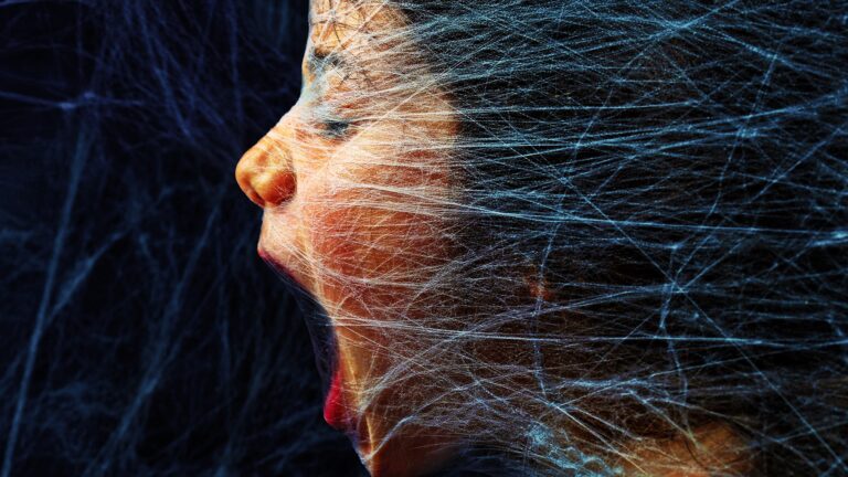 A woman's face pressing through spider webs introduces our blog, 5 Frightful Paid Search Account Mistakes (& How To Fix Them)