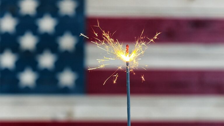 A sparkler burns in front of an American Flag to introduce our post,